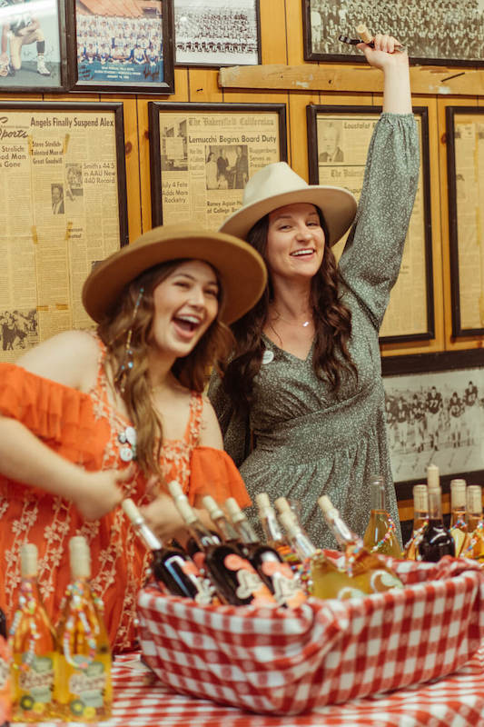 girls laughing and opening wine bottles