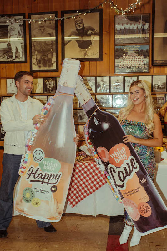 jess druey and friend posing with wine bottle prints